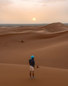 Rui posing in the dunes of Morocco's desert during a beautiful sunset